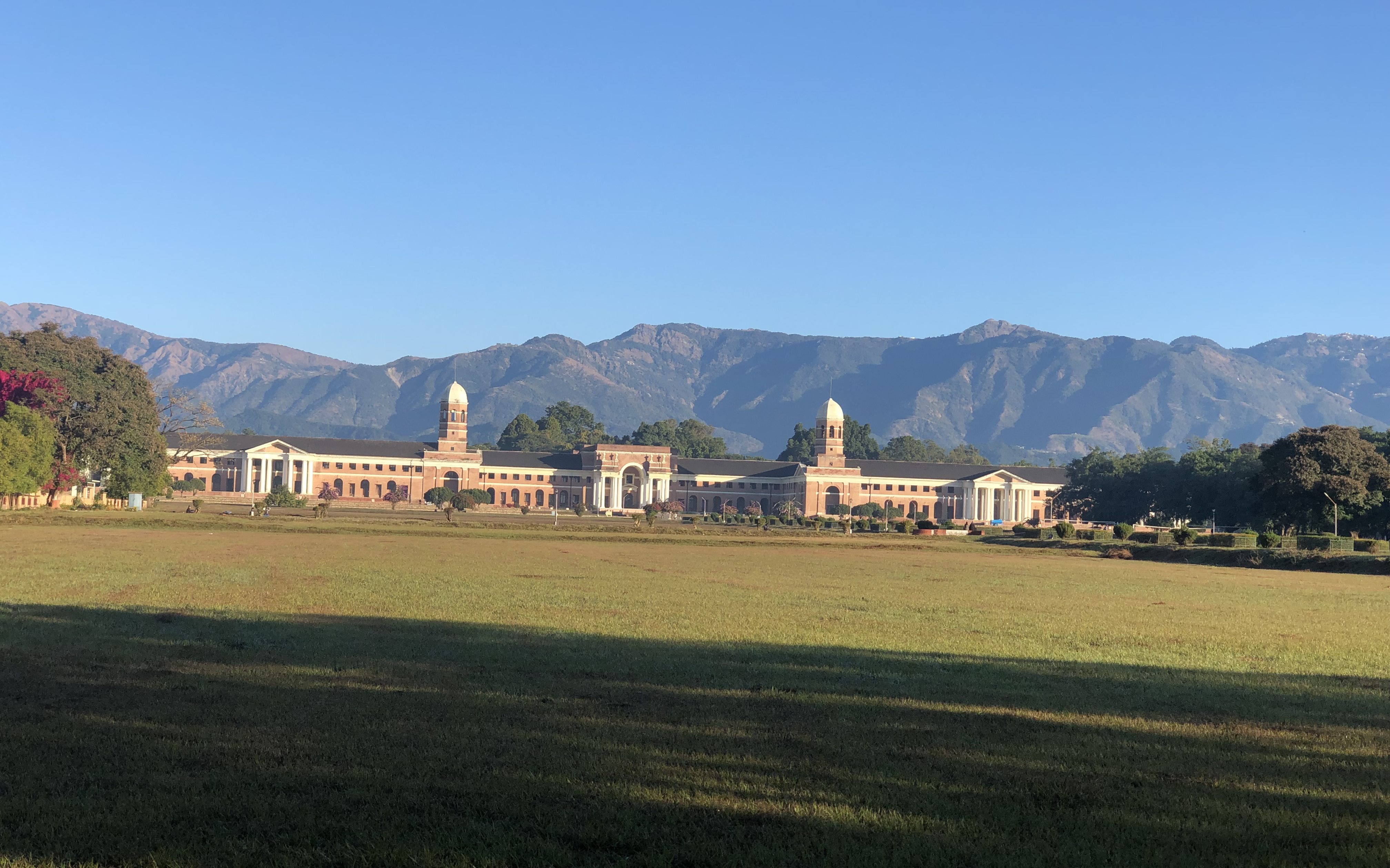 Forest Research Institute (FRI) shining bright against the backdrop of mountains. 